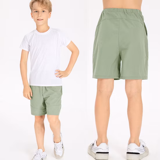 Venta al por mayor de fábrica, pantalones cortos deportivos holgados para niños jóvenes, pantalones cortos de secado rápido con bolsillo para niños, pantalones cortos de baloncesto activos en monopatín